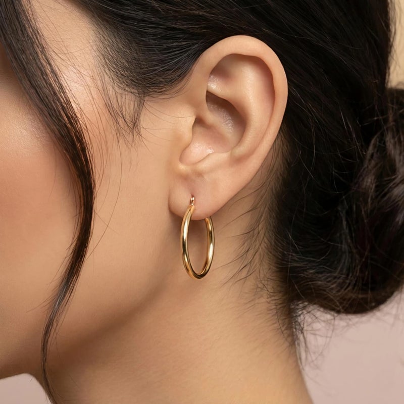 حلق دائري ذهبي متوسط الحجم مصنوع من الستانلس ستيل المقاوم للصدأ، تصميم انسيابي أنيق لامع. 
خفيف ومريح، يضيف لمسة عصرية ناعمة لإطلالتكِ اليومية. - Image 2